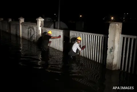 Palestinian workers work in a flooded street with sewage in al-Sabra neighborhood, in Gaza City on November 13, 2013. The main pump of sewage water which serves thousands of citizens in a densely populated area was stope...