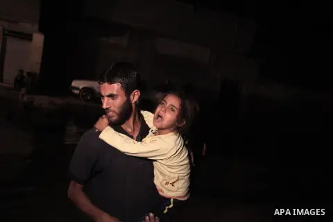 A Palestinian man carries his daughter as he walks in a flooded street with sewage in al-Sabra neighborhood, in Gaza City on November 13, 2013. The main pump of sewage water which serves thousands of citizens in a densel...