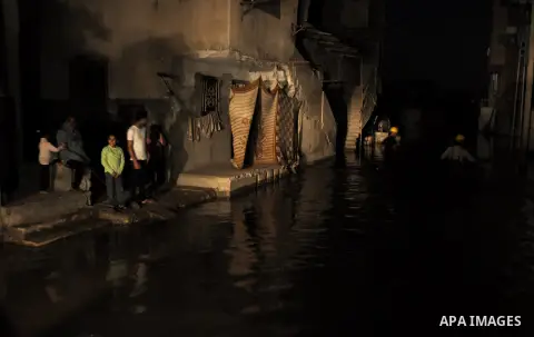 A Palestinian worker wrorks in a flooded street with sewage in al-Sabra neighborhood, in Gaza City on November 13, 2013. The main pump of sewage water which serves thousands of citizens in a densely populated area was st...