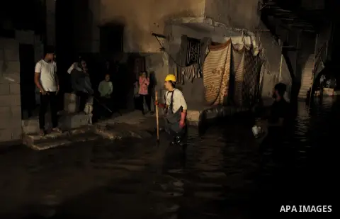 A Palestinian worker wrorks in a flooded street with sewage in al-Sabra neighborhood, in Gaza City on November 13, 2013. The main pump of sewage water which serves thousands of citizens in a densely populated area was st...
