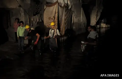 Palestinian workers work in a flooded street with sewage in al-Sabra neighborhood, in Gaza City on November 13, 2013. The main pump of sewage water which serves thousands of citizens in a densely populated area was stope...