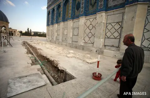 A Palestinian man stands next to a ditch during a restoration work in front of the Dome of the Rock mosque at the al-Aqsa compound, in Jerusalem's old city on November 13, 2013. Restoration works started at al-Aqsa compo...