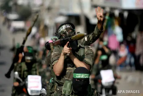 Palestinian militants of the Ezzedine al-Qassam brigade, the armed wing Hamas, parade with guns in Rafah, southern Gaza Strip, on November 14, 2013, during an anti-Israel march as part of the celebrations marking the fir...