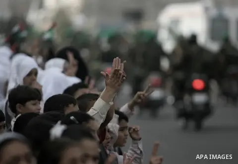 Palestinian militants of the Ezzedine al-Qassam brigade, the armed wing Hamas, parade with guns in Rafah, southern Gaza Strip, on November 14, 2013, during an anti-Israel march as part of the celebrations marking the fir...
