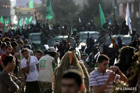 Palestinian militants of the Ezzedine al-Qassam Brigades, Hamas's armed wing, stage an anti-Israel parade as part of the celebrations marking the first anniversary of an Israeli army operation in Gaza, on November 14, 20...