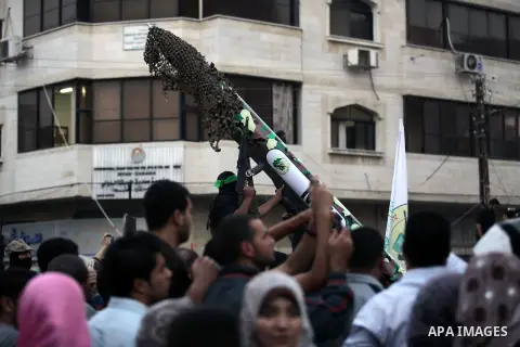 Palestinian militants of the Ezzedine al-Qassam Brigades, Hamas's armed wing, take part in an anti-Israel parade as part of the celebrations marking the first anniversary of an Israeli army operation in Gaza, on November...
