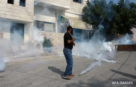 Palestinian protesters throw stone towards Israeli security forces during clashes following a protest against the expropriation of Palestinian land by Israel in the village of Kfar Qaddum, near the occupied West Bank cit...
