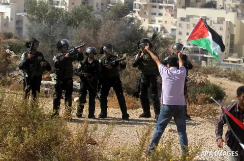 Israeli border policemen fire tear gas at protestors during the weekly demonstration against Israel's separation barrier in the West Bank village of Bilin, near Ramallah, Friday, Nov. 15, 2013. Photo by Issam Rimawi
