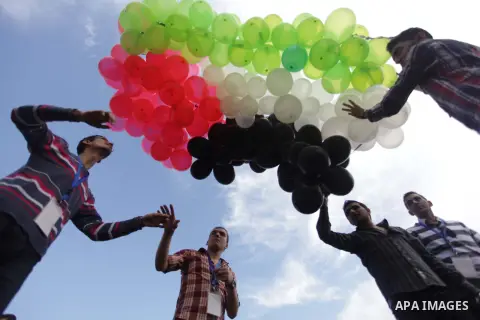 Palestinians hold balloons in the colour of the national flag to mark the 25th anniversary of the Palestinian Independence Day, in Gaza city, on Nov. 17, 2013. Palestinians have marked Nov. 15 as their Independence Day s...
