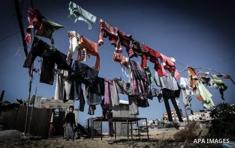 Palestinian children play outside their tin shacks in Khan Younis refugee camp, in southern Gaza Strip, November 21, 2013. The UNRWA, which is facing a 36-million dollar deficit, halted 19 out of 20 construction projects...