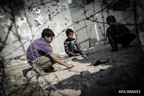 Palestinian children play outside their tin shacks in Khan Younis refugee camp, in southern Gaza Strip, November 21, 2013. The UNRWA, which is facing a 36-million dollar deficit, halted 19 out of 20 construction projects...