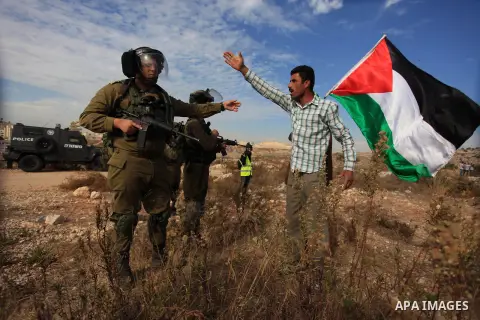 A Palestinian man argues with Israeli border policemen during the weekly demonstration against Israel's separation barrier in the West Bank village of Bilin, near Ramallah, Friday, Nov. 22, 2013. Photo by Issam Rimawi
