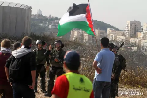 Palestinians argue with Israeli border policemen during the weekly demonstration against Israel's separation barrier in the West Bank village of Bilin, near Ramallah, Friday, Nov. 22, 2013. Photo by Issam Rimawi
