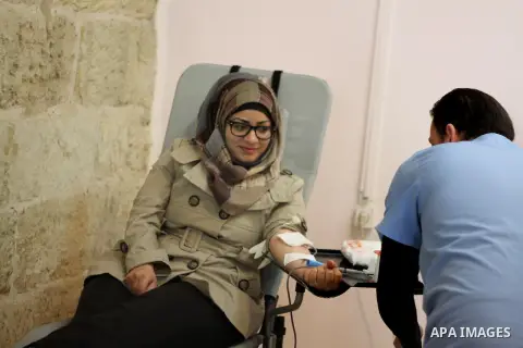 Palestinian woman donates blood during the launch of campaign " the good gathered" in the West Bank city of Ramallah on Nov. 23, 2013. Photo by Issam Rimawi