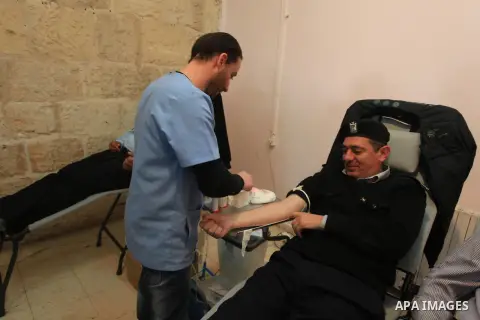 Palestinian policeman donates blood during the launch of campaign " the good gathered" in the West Bank city of Ramallah on Nov. 23, 2013. Photo by Issam Rimawi
