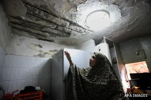 A Palestinian woman gestures to the cracks on a wall at her home in the old town of Jerusalem, Nov. 23, 2013. Landslides began seven years ago due to the network of tunnels that Jerusalem's municipality is digging that e...