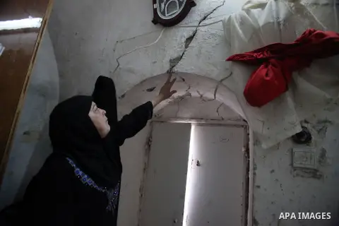 A Palestinian woman gestures to the cracks on a wall at her home in the old town of Jerusalem, Nov. 23, 2013. Landslides began seven years ago due to the network of tunnels that Jerusalem's municipality is digging that e...