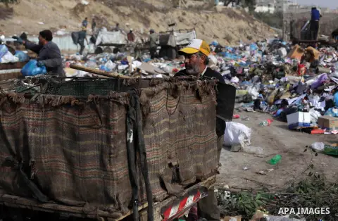 Palestinian workers of the Gaza municipality collect rubbish at a landfill sites in the compound of Yarmouk, in Gaza city, on Nov. 24, 2013. Gaza Municipality announced stop working its waste cars due to a fuel shortage....
