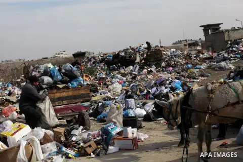 Palestinian workers of the Gaza municipality collect rubbish at a landfill sites in the compound of Yarmouk, in Gaza city, on Nov. 24, 2013. Gaza Municipality announced stop working its waste cars due to a fuel shortage....