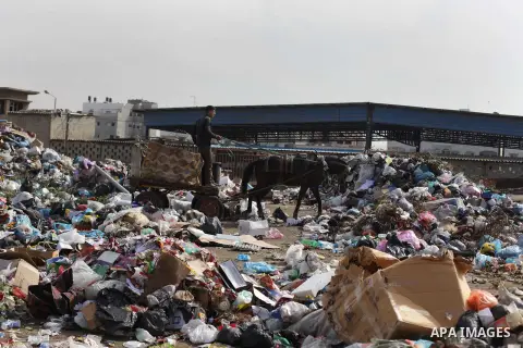 Palestinian workers of the Gaza municipality collect rubbish at a landfill sites in the compound of Yarmouk, in Gaza city, on Nov. 24, 2013. Gaza Municipality announced stop working its waste cars due to a fuel shortage....