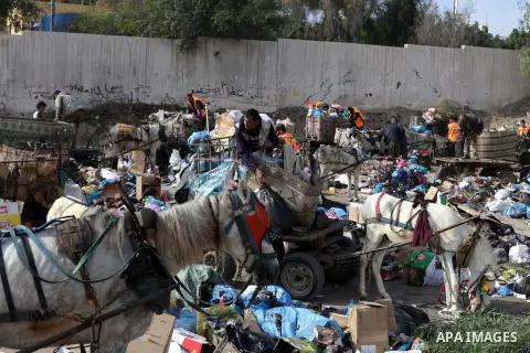 Palestinian workers of the Gaza municipality collect rubbish at a landfill sites in the compound of Yarmouk, in Gaza city, on Nov. 24, 2013. Gaza Municipality announced stop working its waste cars due to a fuel shortage....