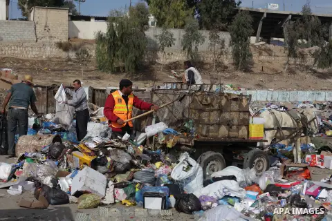 Palestinian workers of the Gaza municipality collect rubbish at a landfill sites in the compound of Yarmouk, in Gaza city, on Nov. 24, 2013. Gaza Municipality announced stop working its waste cars due to a fuel shortage....