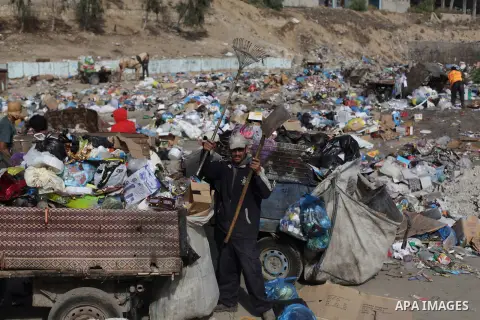 Palestinian workers of the Gaza municipality collect rubbish at a landfill sites in the compound of Yarmouk, in Gaza city, on Nov. 24, 2013. Gaza Municipality announced stop working its waste cars due to a fuel shortage....