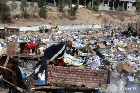 Palestinian workers of the Gaza municipality collect rubbish at a landfill sites in the compound of Yarmouk, in Gaza city, on Nov. 24, 2013. Gaza Municipality announced stop working its waste cars due to a fuel shortage....