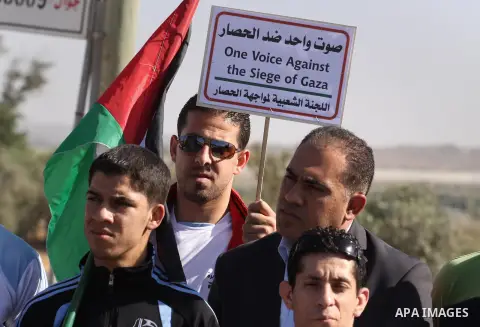 Palestinians and foreigners take part in a protest against the Israeli blockade on Gaza, at Erez crossing between Israel and Gaza Strip November 26, 2013. Israel imposed a blockade on Gaza in 2007 after Islamist group Ha...