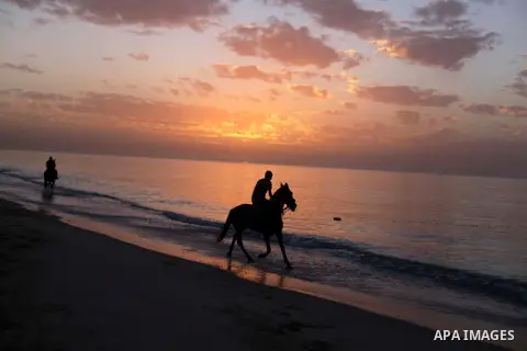 A Palestinian man rides a horse on the beach of the Mediterranean Sea during the sunset in Deir al-Balah in central Gaza Strip, Tuesday, Nov. 26, 2013. Photo by Ashraf Amra