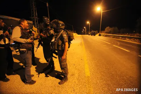 Israeli soldiers stand at the scene of a shooting in which three Palestinians were shot dead by the Israeli army in the village of Yatta, south of the West Bank city of Hebron, on November 26, 2013. Israeli forces shot a...
