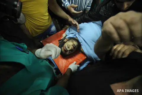 Palestinians stand beside the body of a militant at a hospital in Yatta village of the West Bank city of Hebron on Nov. 27, 2013. Israeli forces killed three Palestinian militants Tuesday in clashes near the West Bank ci...