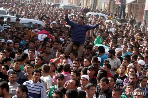Mourners carry the bodies of Palestinian militants Mahmoud al-Najjar, and Moses Makhamreh, during their funeral on November 27, 2013 in the West Bank village of Yatta, one day after he was shot dead, along with two other...