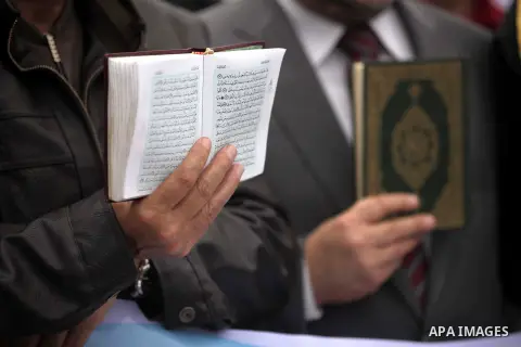 A Palestinian protester holds a copy of holy Quran during a protest against Angola's government, in Gaza City on November 27, 2013. Angola's government on November 26, 2013 denied it had banned Islam and closed mosques i...