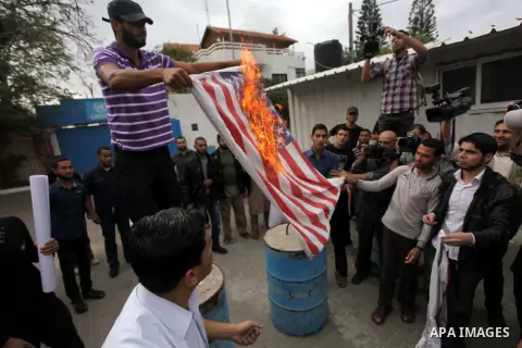 Palestinian protester burn a U.s flag during a protest against Angola's government, in Gaza City on November 27, 2013. Angola's government on November 26, 2013 denied it had banned Islam and closed mosques in the country...