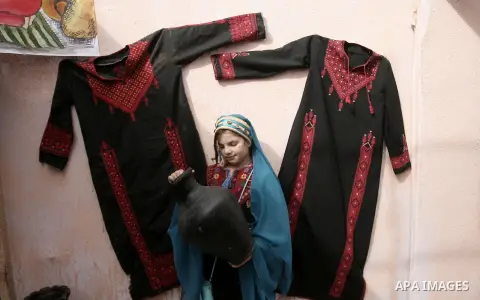 A Palestinian girl takes part in the Palestinian Heritage Exhibition in the town of Khan Yunis, in the southern Gaza Strip, November 27, 2013. Palestinians attend the Heritage Exhibition every year to practice heritage r...