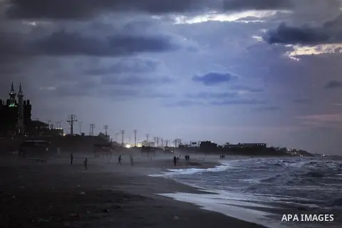 Palestinians walk on the beach of Gaza City on 28, 2013. The UN started distributing fuel in Gaza to maintain operations of critical facilities amid fears of a health crisis due to gathering garbage and sewage, Robert Se...