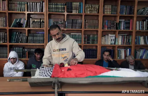 A Palestinian man takes farewell look at the body of Mahmud Waji Awad, a Palestinian man who died the previous day of his injuries after he was shot in a 2012 clash with Israeli troops, during his funeral in the West Ban...