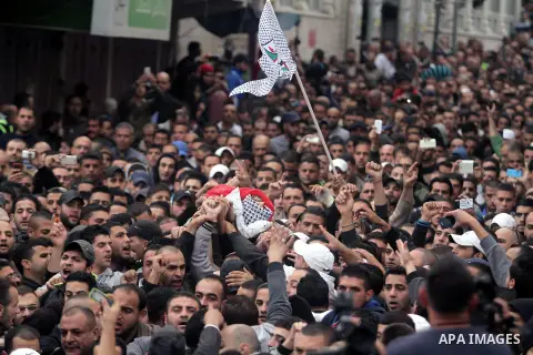 Palestinian mourners carry the body of Mahmud Waji Awad, a Palestinian man who died the previous day of his injuries after he was shot in a 2012 clash with Israeli troops, during his funeral in the West Bank's Qalandiya...