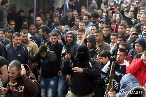 Members of the Al-Aqsa Martyrs' Brigade, the armed wing of Fatah movement, fire into the air during the funeral of Mahmud Waji Awad, a Palestinian man who died the previous day of his injuries after he was shot in a 2012...