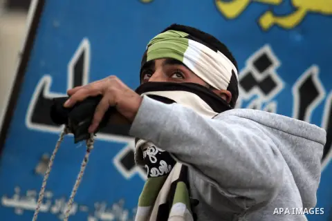 A Palestinian protester throw stones at Israeli security forces during clashes following a demonstration against the killing of Mahmud Waji Awad, a Palestinian man who died the previous day of his injuries after he was s...