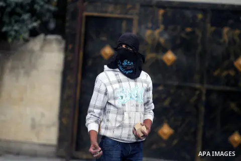 A Palestinian protester throw stones at Israeli security forces during clashes following a demonstration against the killing of Mahmud Waji Awad, a Palestinian man who died the previous day of his injuries after he was s...