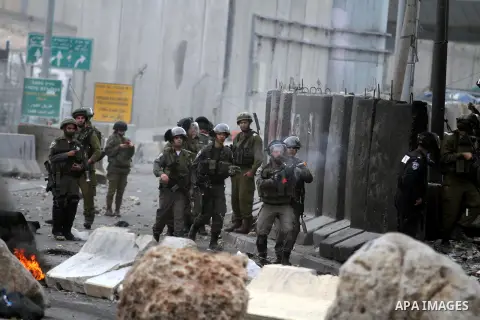 A member of Israeli security forces fires a tear gas canister towards Palestinian protesters during clashes following a demonstration against the killing of Mahmud Waji Awad, a Palestinian man who died the previous day o...