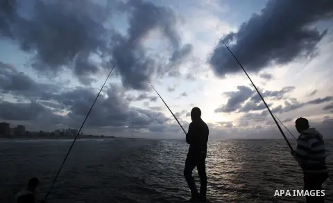 Palestinians are seen fishing on the beach during the power cut in Gaza City November 29, 2013. Chief of the Palestinian Power Authority Omar Kittanah said Tuesday that the Palestinian Authority was exerting serious effo...