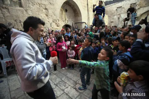 Palestinian children take part in an activities to encourage people of the area to stay in their homes Al-Qurma neighborhood of the Old City, on Nov. 30, 2013. Landslides began seven years ago due to the network of tunne...