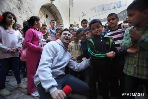 Palestinian children take part in an activities to encourage people of the area to stay in their homes Al-Qurma neighborhood of the Old City, on Nov. 30, 2013. Landslides began seven years ago due to the network of tunne...