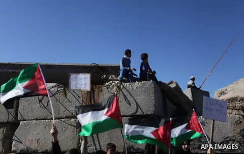 Palestinians hold flags and paper ships reading in Arabic "No to the siege" during a rally to protest against the Israeli siege of the Gaza Strip on November 30, 2013 at Gaza City harbour. Photo by Ashraf Amra