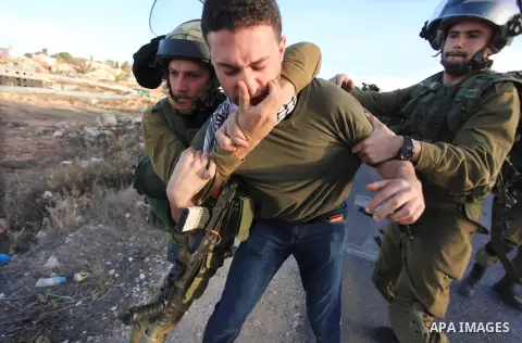 Israeli soldiers detain a Palestinian protester after clashes erupted during a protest against Israel's plan of forced relocation for Bedouin residents in the southern Negev, outside the Beit El settlement near the West...