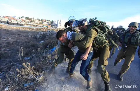 Israeli soldiers detain a Palestinian protester after clashes erupted during a protest against Israel's plan of forced relocation for Bedouin residents in the southern Negev, outside the Beit El settlement near the West...