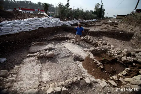 An Israeli Israel Antiquities Authority employee inspects a site of excavation revealed at the main access road to Israeli settlement of Beit Shemesh, near Jerusalem on Dec. 01, 2013. An archaeological excavation near Je...
